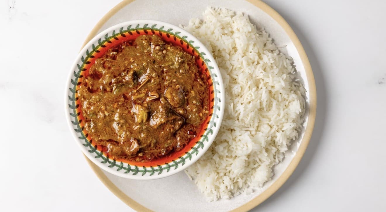 Soupe Kandia okra stew with goat meat — deep greens, palm oil sheen